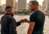 Mike and Marcus dap each other up in front of the water