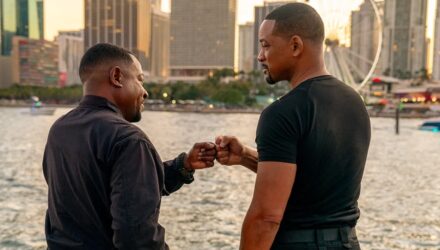 Mike and Marcus dap each other up in front of the water