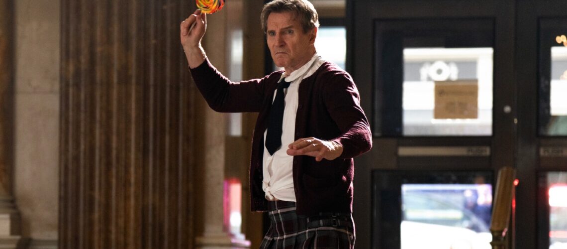 Liam Neeson in school girl outfit about to throw a lollipop from The Naked Gun